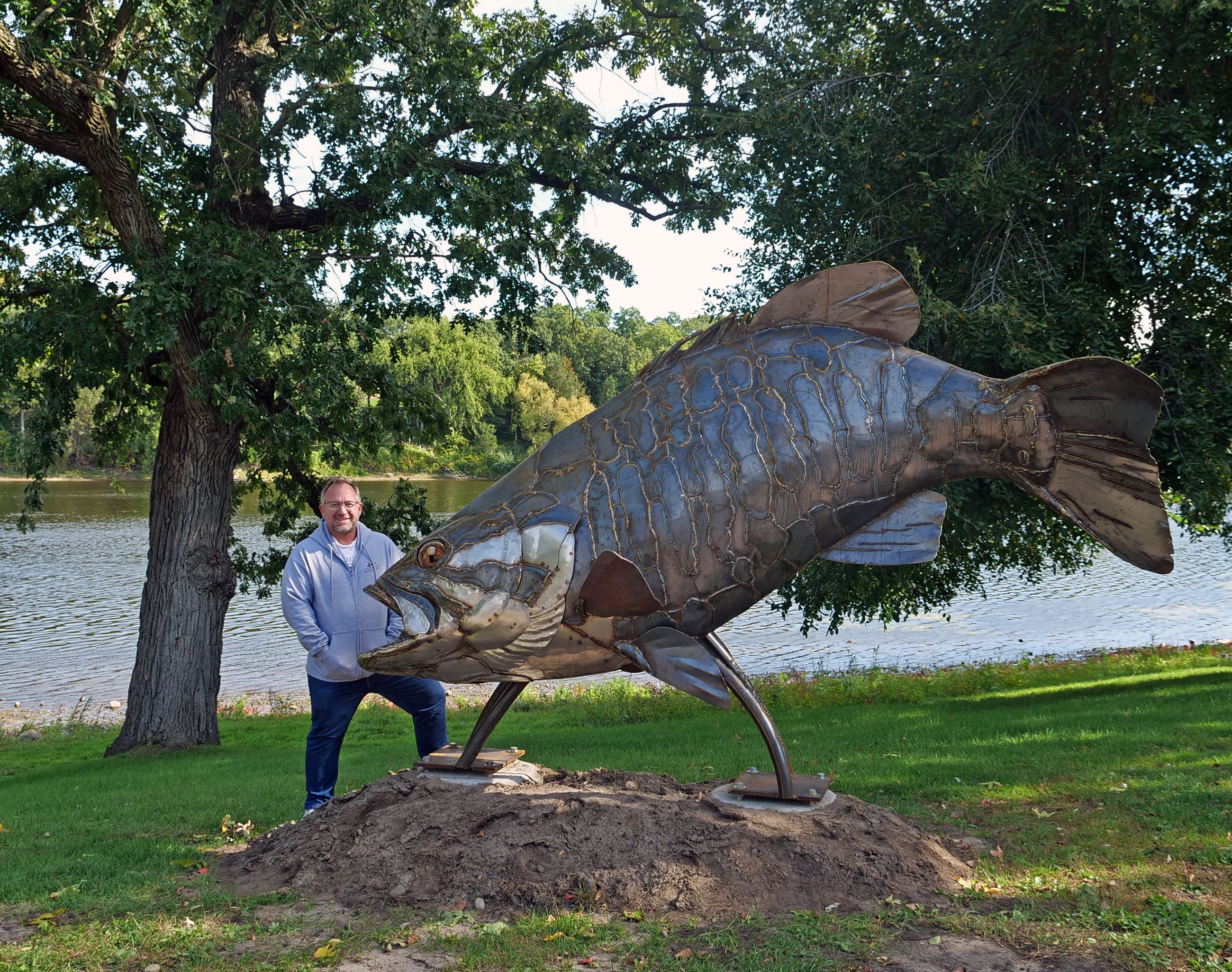 Mayor Hilgart posing with the sculpture