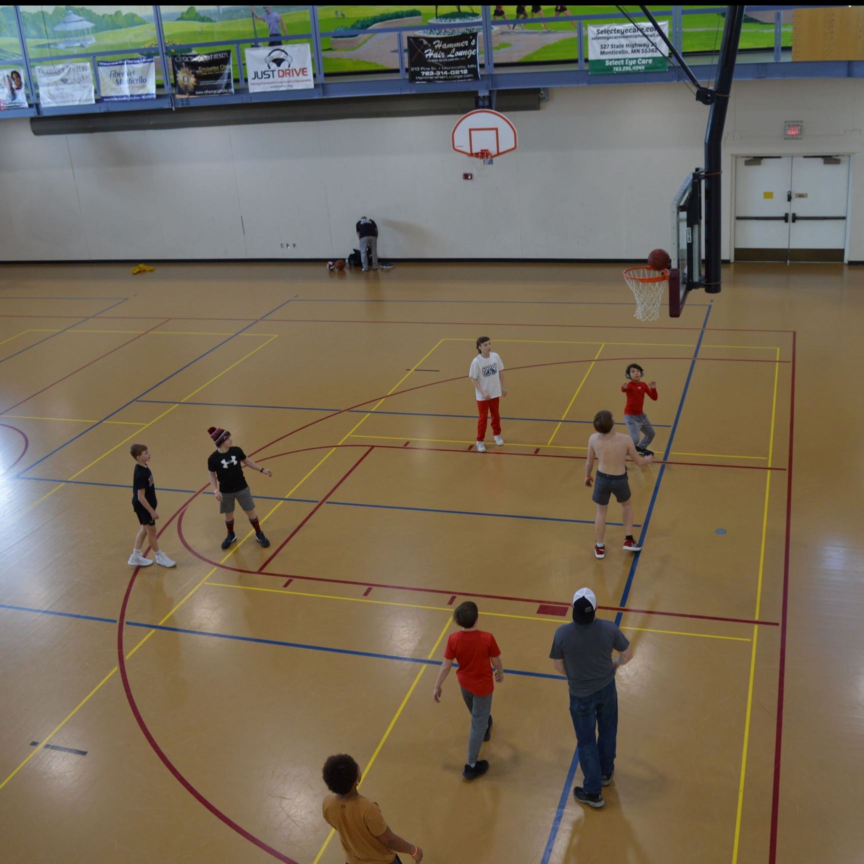 Kids playing basketball in gymnasium.
