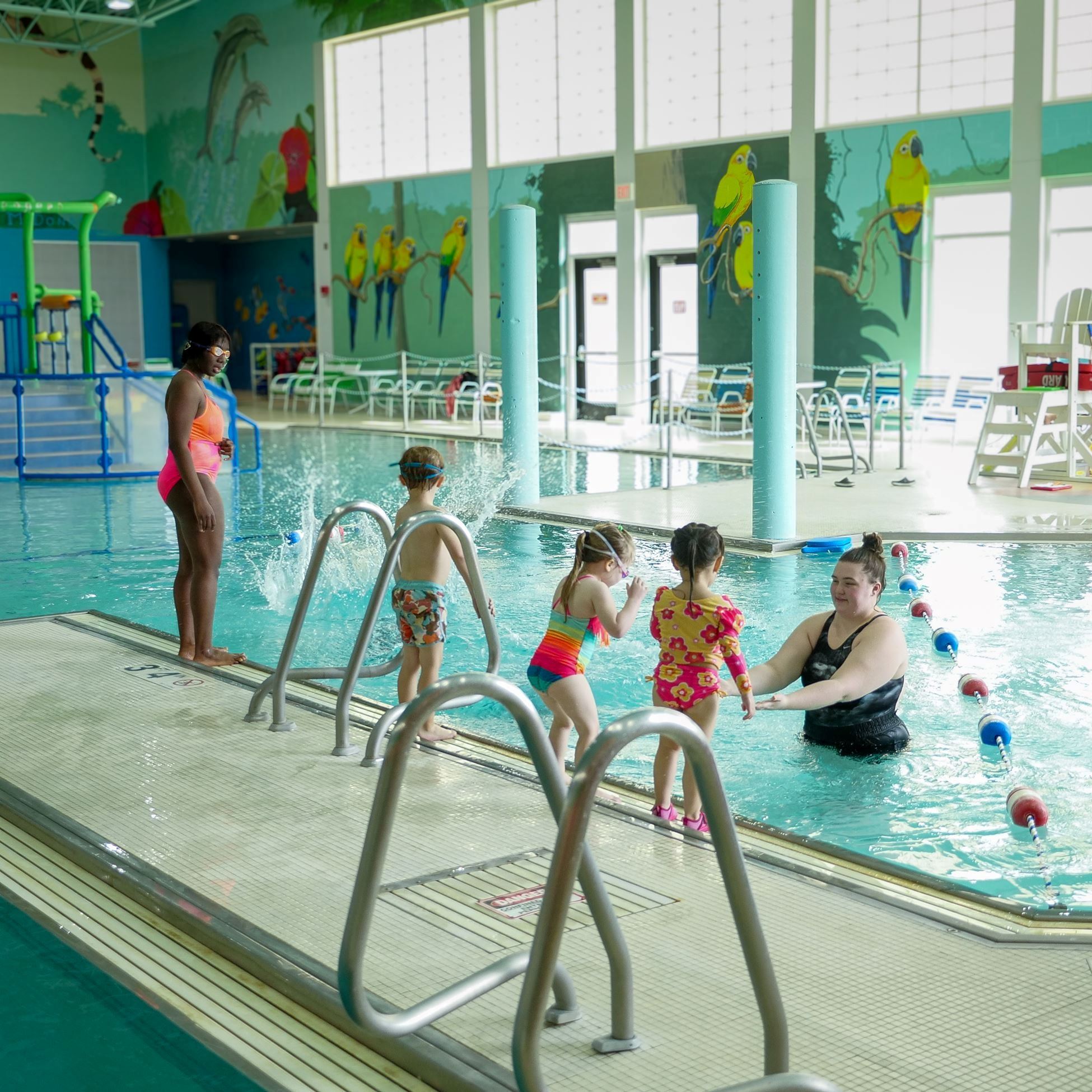 Kids standing outside of an indoor pool for lessons.